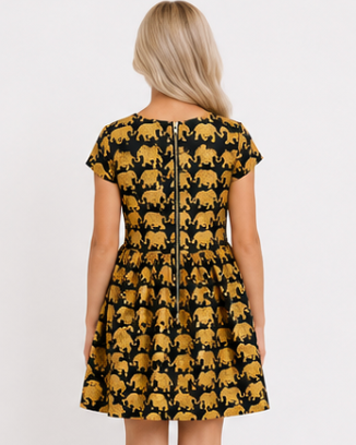 Woman wearing a dress with gold elephant pattern on a white background