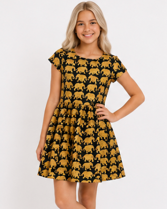 Young girl wearing a black dress with gold elephant pattern on a white background