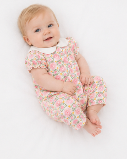 Baby wearing a floral onesie on a white background