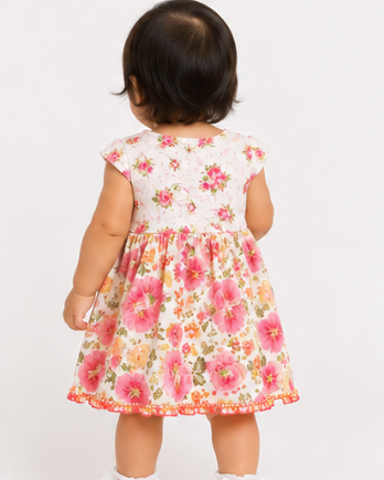 Child wearing a floral dress on a white background