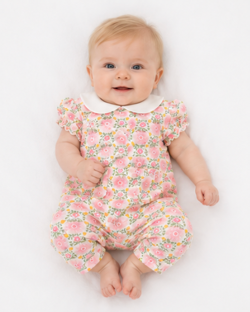 Baby wearing a floral outfit on a white background