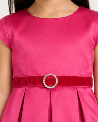 Close-up of a pink dress with belt featuring a buckle.