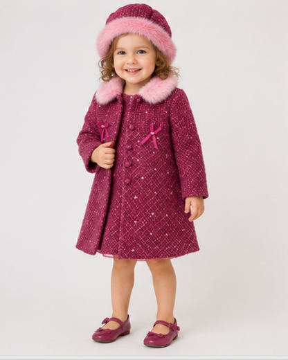 Child wearing a pink coat with fur trim and matching shoes on a white background