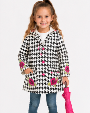 Child wearing a black and white checkered coat with floral patterns, blue jeans, and yellow boots, holding a pink umbrella on a white background.