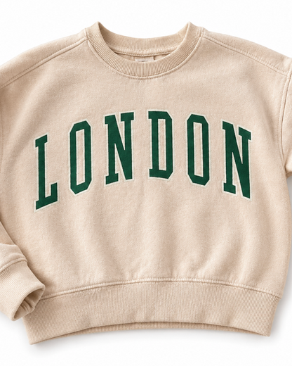 Beige sweatshirt with 'London' text and British flag on a white background