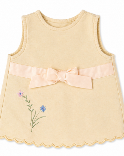 Yellow sleeveless top with a bow and floral embroidery on a white background